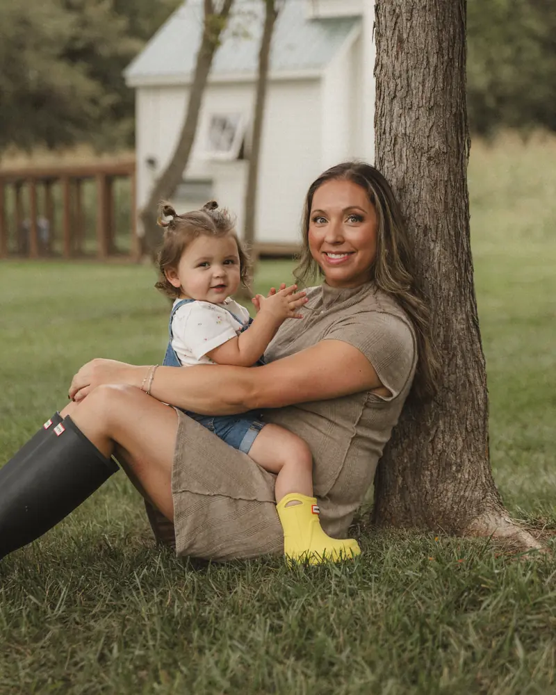 Alli sitting against a tree with Summer on her lap